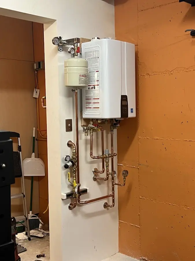 Plumbing technician inspecting water heater connections in Arcola